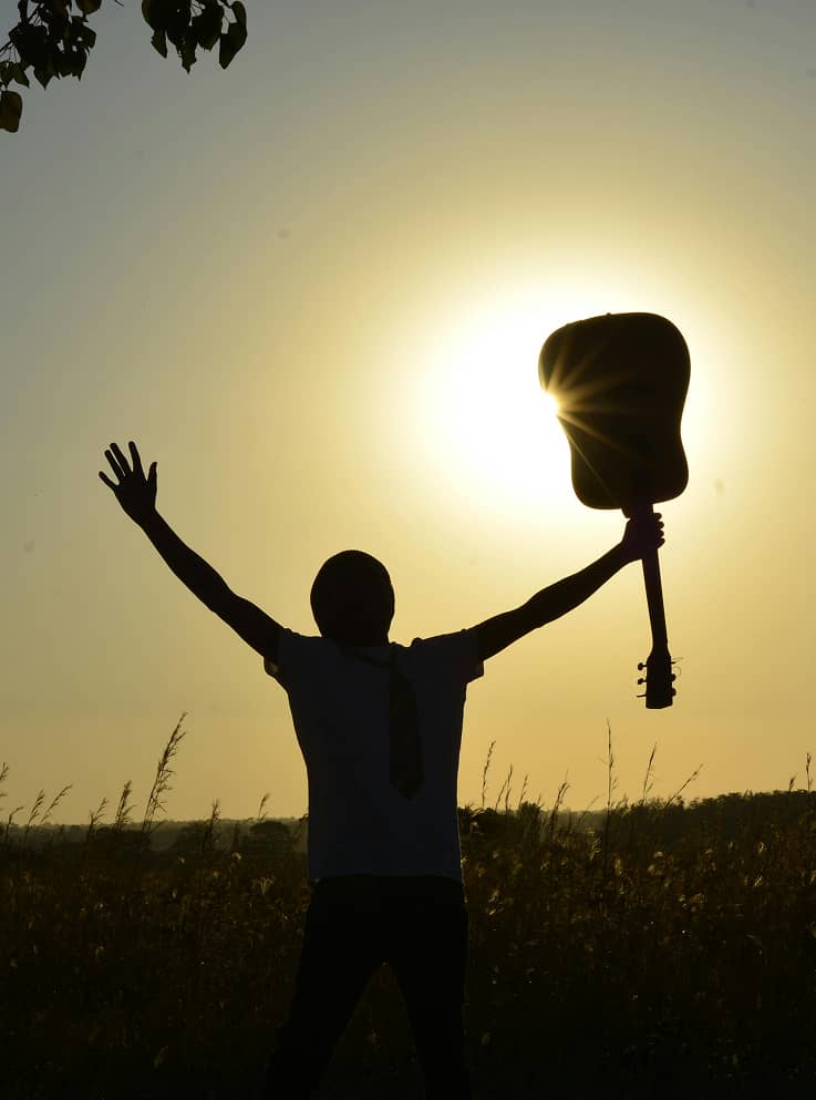 man raising a guitar triumphantly